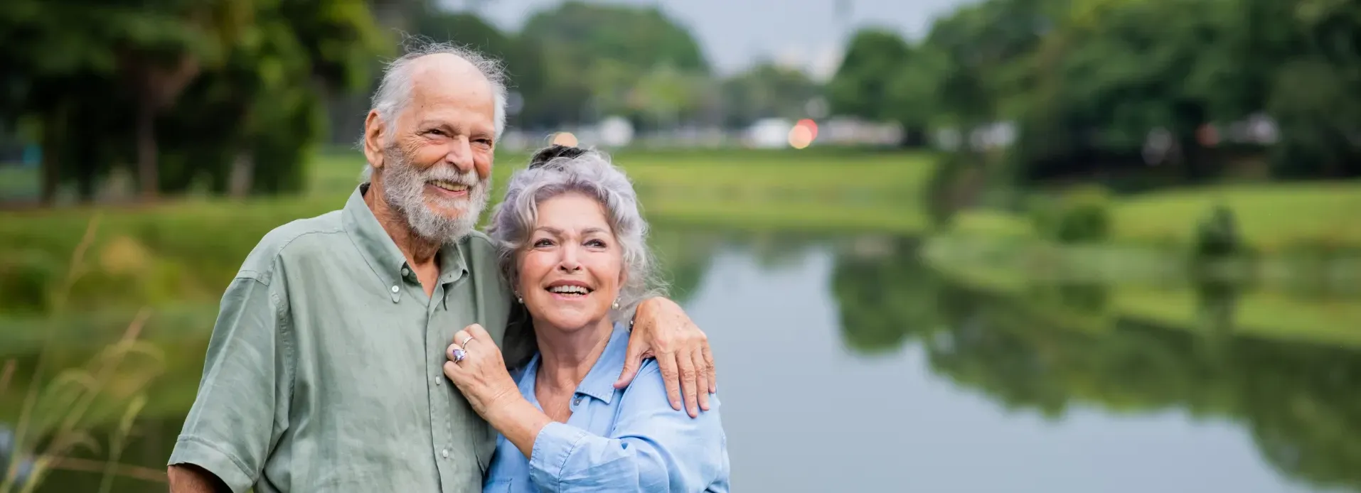 elderly-couple-hugging-and-smiling-in-park